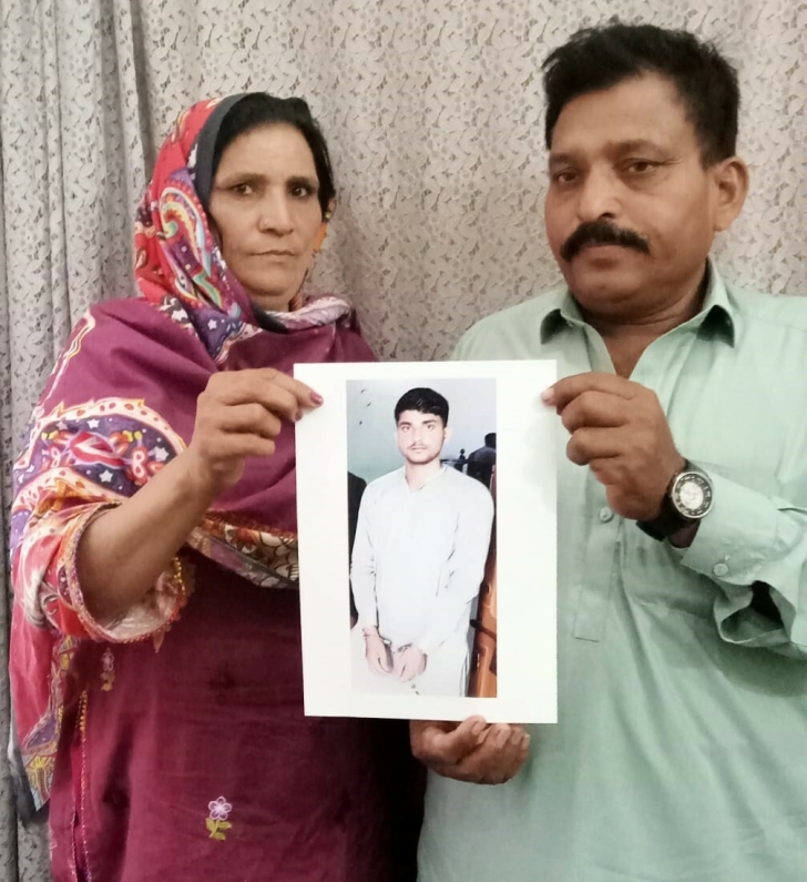 Parents of Noman Masih hold a photograph of their imprisoned son.