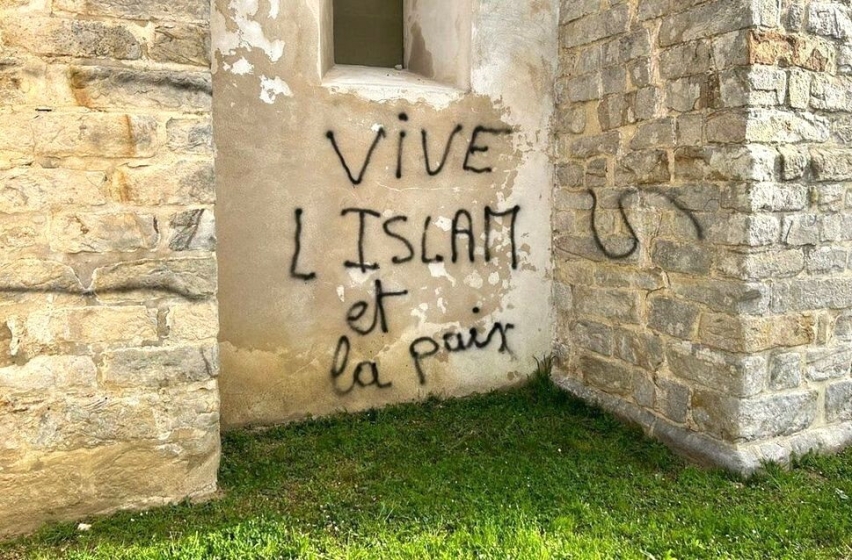 Defaced Catholic church building in Lieusaint, France.