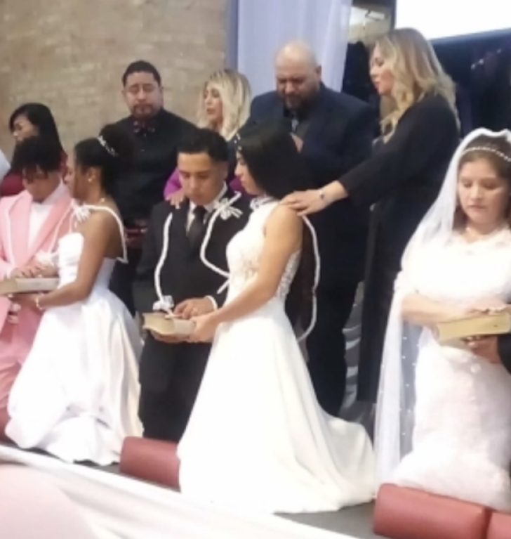 Couples laying their hands on the QR Bible