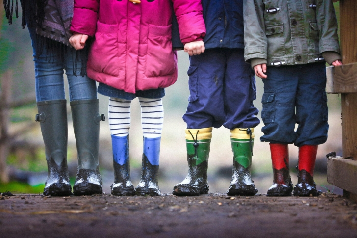 children standing in rain boots