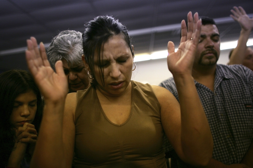 A Latino family prays inside the Streets of Destiny Church in Phoenix, Arizona