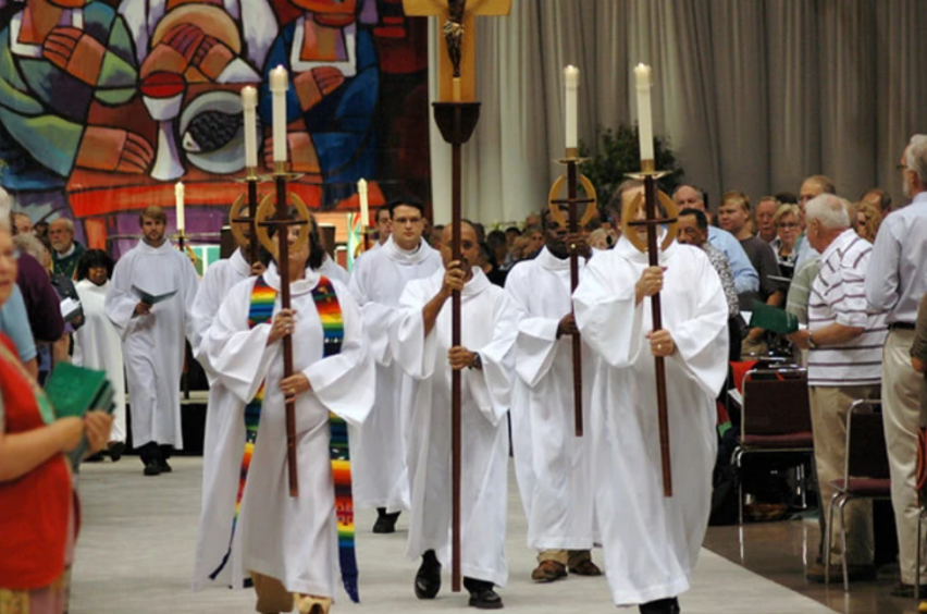 Clergy with the Evangelical Lutheran Church in America carry candles down an aisle in this undated file photo.