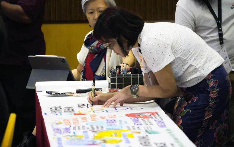 Wendy, a visual scribe from Singapore, draws and writes in real time during a session at the Arise Leadership Summit 2025, capturing key insights and stories through live illustration as a form of visual witness.