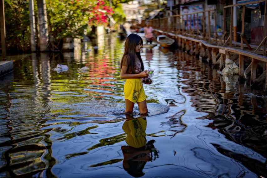 A resident wades through floodwater in Dela Paz village, Laguna province, after Tropical Storm Trami in 2024. Lawmakers and church leaders warn that corruption and defective flood control projects have worsened the impact of disasters in one of the world’