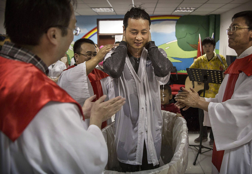 A Chinese Christian man stands after being baptized by a pastor during a ceremony at an underground independent Protestant church on October 12, 2014 in Beijing, China. According to the widest definition used by researchers, China is home to the largest e