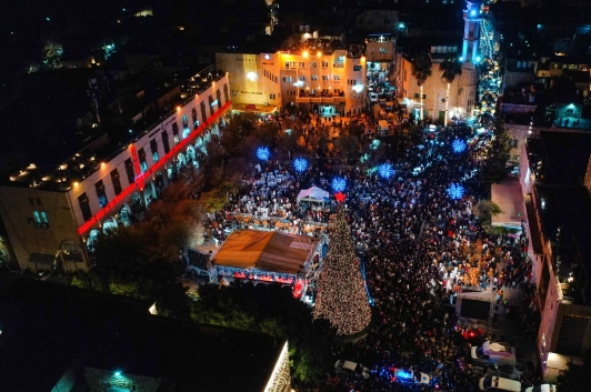 An aerial view of Bethlehem’s Manger Square shows large crowds gathered around the illuminated Christmas tree during the city’s first public celebration in two years.