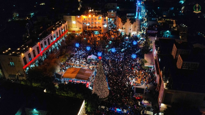 An aerial view of Bethlehem’s Manger Square shows large crowds gathered around the illuminated Christmas tree during the city’s first public celebration in two years.