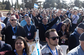 Members of a US delegation pray and wave Israeli flags as they gather at Mount Herzl to meet with families of soldiers killed during the Oct 7 war on December 3, 2025 in Jerusalem, Israel.