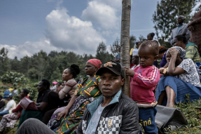 A father and child on a hillside where mourners attend the July 11, 2025, funeral of Boniface Kariuki in Iyego village, Murang’a County, Kenya