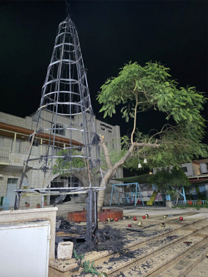 The remains of the burned Christmas tree are seen outside the Latin Church in Jenin after an arson attack.