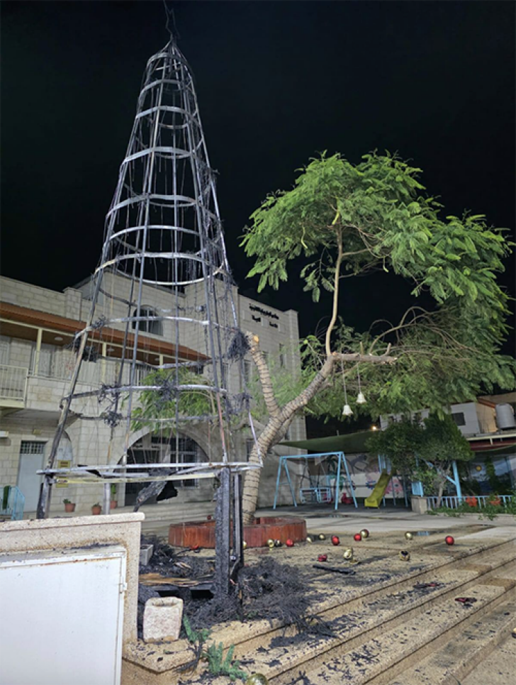 The remains of the burned Christmas tree are seen outside the Latin Church in Jenin after an arson attack.