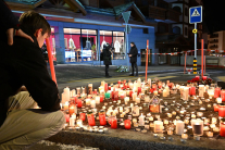 Mourners light candles at the scene after a fire broke out overnight at Le Constellation bar on January 01, 2026 in Crans-Montana, Switzerland.