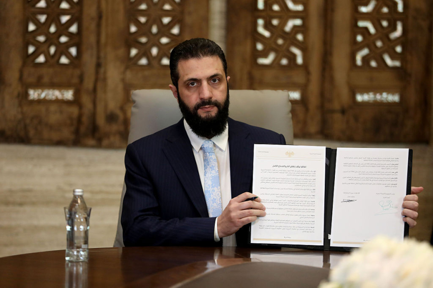 Syrian President Ahmed Al-Sharaa speaks to media as he signs a ceasefire agreement with the Kurdish-led Syrian Democratic Forces (SDF) on January 18, 2026 in Damascus, Syria