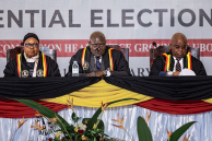 The Ugandan Electoral Commission Chairman, Justice Byabakama Mugenyi Simon (C) among with other Electoral Commission officials anounces the result of the 2026 elections at the Tally Centre on January 16, 2026 in Lubowa, Uganda.