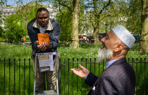 A Christian and a Muslim engage in a public debate at Speaker’s Corner in Hyde Park in London, UK, where open discussions on religion and belief have long been a feature of public life.