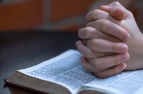 Young prayer on Bible