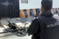 Police officers inspect the area outside the U.S. Consulate in Karachi, Pakistan, following violent protests linked to the escalating U.S.–Israel conflict with Iran. Authorities reinforced security at diplomatic missions and Christian institutions across 