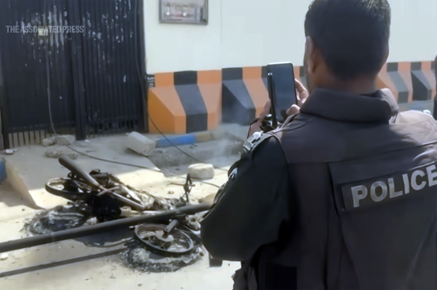Police officers inspect the area outside the U.S. Consulate in Karachi, Pakistan, following violent protests linked to the escalating U.S.–Israel conflict with Iran. Authorities reinforced security at diplomatic missions and Christian institutions across