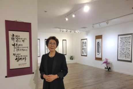 Artist Kim Chang-soon, also known as Laura Kim, stands among her works during her solo exhibition in Los Angeles, which highlighted more than seven decades of calligraphy shaped by faith, perseverance and artistic discipline.