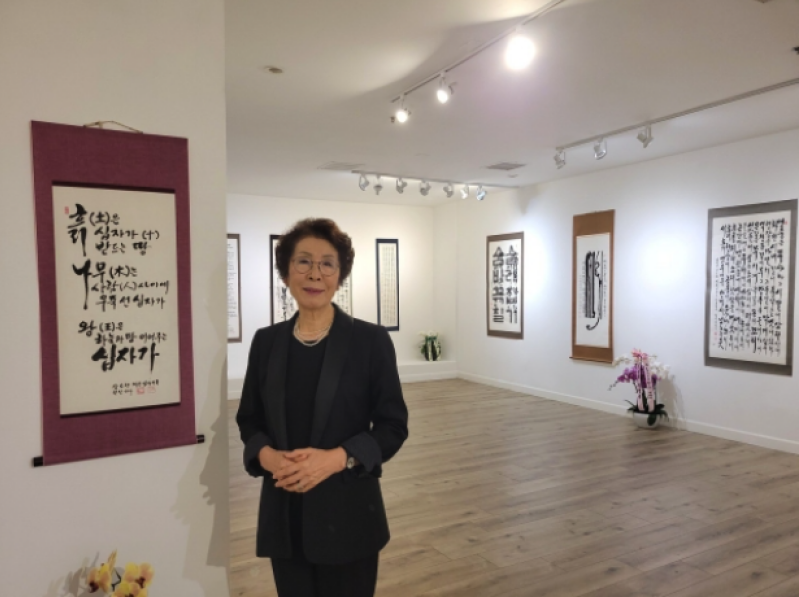 Artist Kim Chang-soon, also known as Laura Kim, stands among her works during her solo exhibition in Los Angeles, which highlighted more than seven decades of calligraphy shaped by faith, perseverance and artistic discipline.