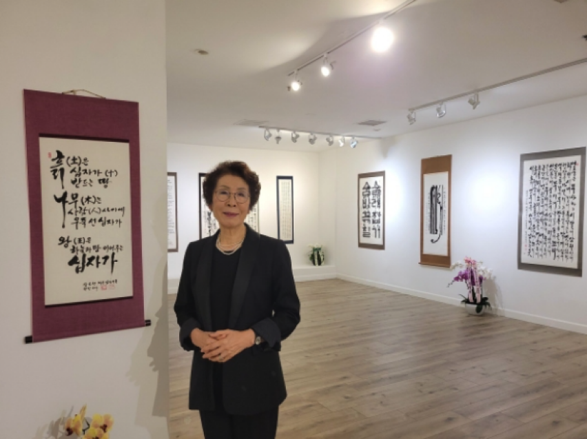 Artist Kim Chang-soon, also known as Laura Kim, stands among her works during her solo exhibition in Los Angeles, which highlighted more than seven decades of calligraphy shaped by faith, perseverance and artistic discipline.