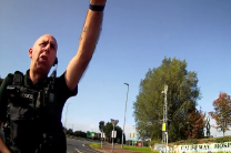 Officer approaches Claire Brennan before arrest outside hospital in Coleraine, Northern Ireland in 2023, before her 2025 arrest at the same site.