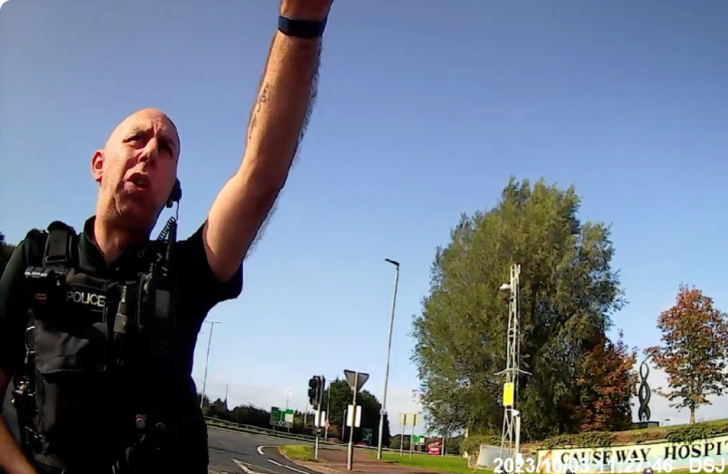 Officer approaches Claire Brennan before arrest outside hospital in Coleraine, Northern Ireland in 2023, before her 2025 arrest at the same site.