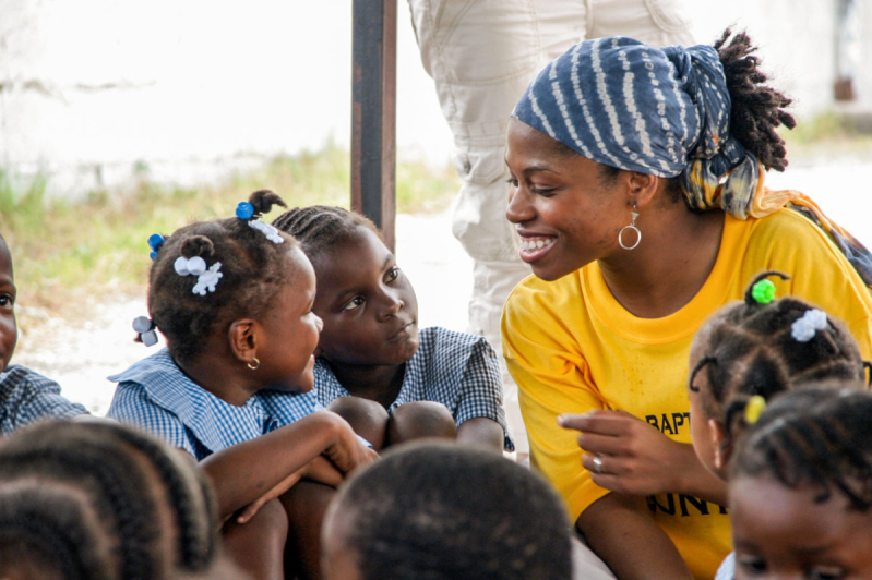 Church volunteer ministers to children in Jamaicas Blue Mountains, reflecting the Christian communitys enduring role in shaping family and education values across the island.
