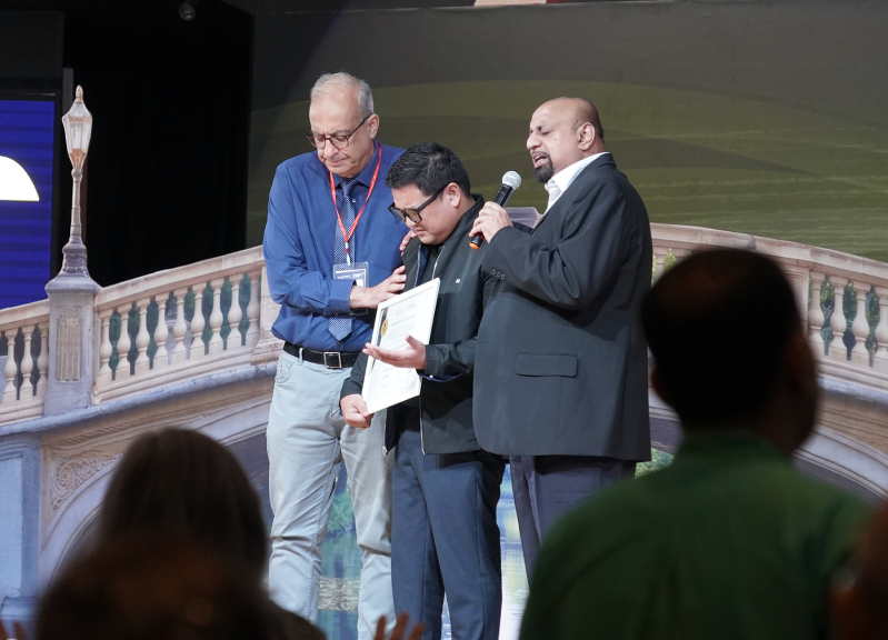 Godfrey Yogarajah (right), Chair of the Asia Evangelical Alliance and the International Council of the World Evangelical Alliance, and Rev. Botrus Mansour (left), Secretary General of the World Evangelical Alliance, pray for Bishop Joel Montes as he recei