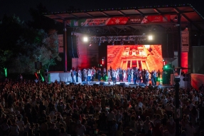 Thousands attend the Visit Jordan Experience, where performers in traditional dress appear onstage before a screen showing Petra.