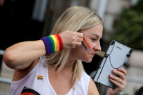 LONDON, ENGLAND - JULY 4: A parade-goer applies rainbow face paint ahead of the Pride In London 2026 parade on July 4, 2026 in London, England.