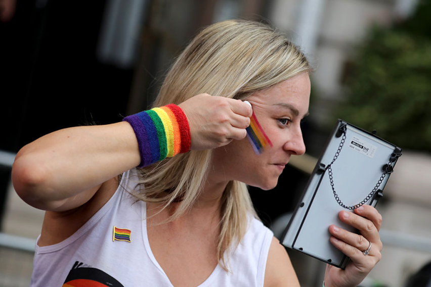 LONDON, ENGLAND - JULY 4: A parade-goer applies rainbow face paint ahead of the Pride In London 2026 parade on July 4, 2026 in London, England.