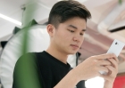 A young adult consults his phone