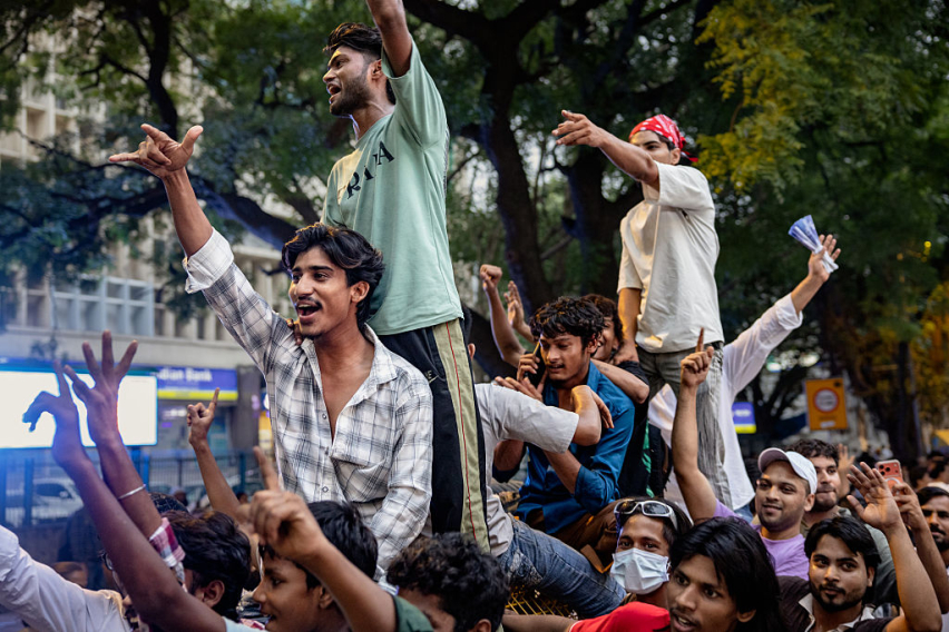 Supporters of Indias Cockroach Janta Party (CJP) ride a barricade during a protest demand the resignation of Education Minister Dharmendra Pradhan over examination paper leaks, at Jantar Mantar on July 24, 2026 in New Delhi, India