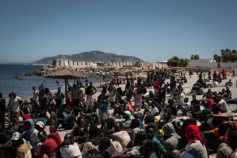 Migrants wait on the beach next to the CETI (Centros de Estancia Temporal de Inmigrantes) on August 2, 2026 in Ceuta, Spain.
