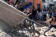 Rescuers and residents search through rubble in Cali, Colombia, following the 7.4-magnitude earthquake that struck the country Monday, Aug. 10.