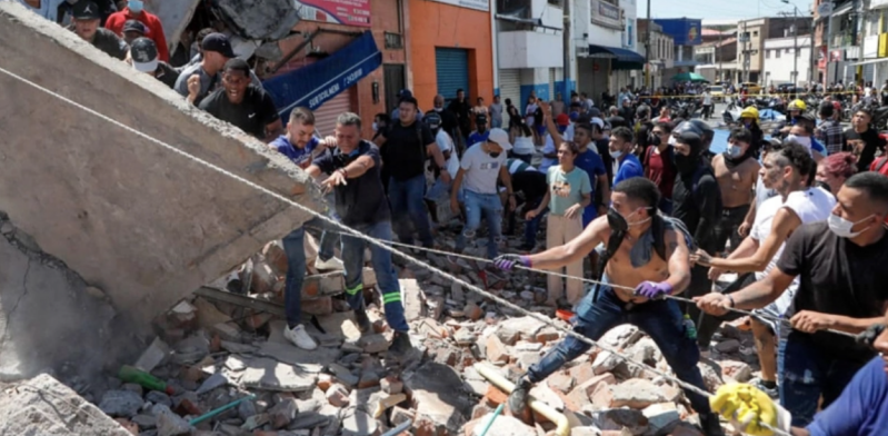 Rescuers and residents search through rubble in Cali, Colombia, following the 7.4-magnitude earthquake that struck the country Monday, Aug. 10.