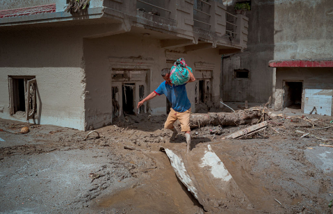 DEVIGHAT, NEPAL - AUGUST 28: A resident carries belongings he salvaged from his destroyed home following flash floods on August 28, 2026 in Devighat, Nepal.