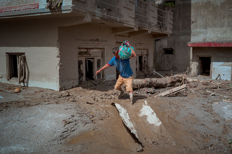 DEVIGHAT, NEPAL - AUGUST 28: A resident carries belongings he salvaged from his destroyed home following flash floods on August 28, 2026 in Devighat, Nepal.