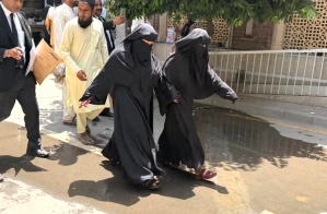 Neha Faqir (R) in Islamic dress on way to court in Lahore, Pakistan.