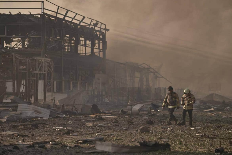 Firefighters walk through the remains of a warehouse and office complex used by the humanitarian ministry of Ukraine for Christ, destroyed in a Russian strike on the evening of Aug. 28, 2026.