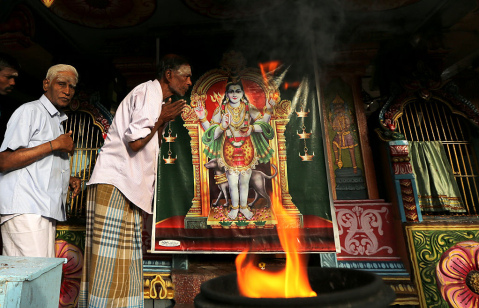 Minority ethnic Tamil men pray in the Hindu temple on August 12,2015 in Jaffna, Sri Lanka.