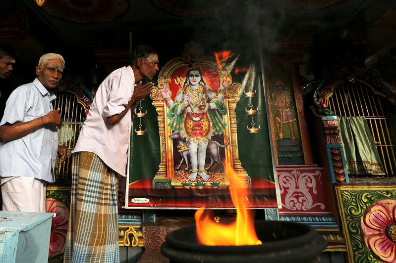 Minority ethnic Tamil men pray in the Hindu temple on August 12,2015 in Jaffna, Sri Lanka.