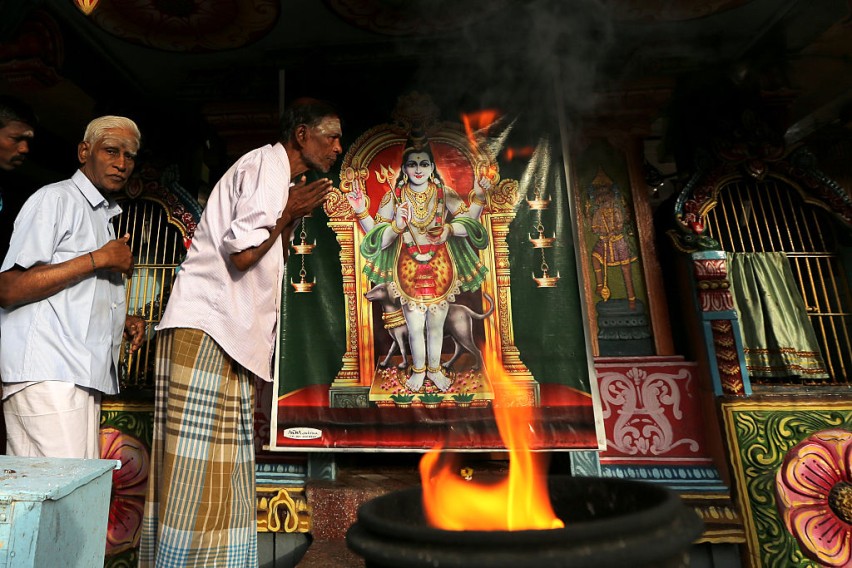 Minority ethnic Tamil men pray in the Hindu temple on August 12,2015 in Jaffna, Sri Lanka.