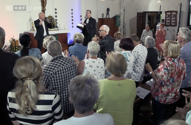 Worshippers clap during the Aug. 23 Schlager service at the Christuskirche in Graz, Austria, broadcast live by ORF III.