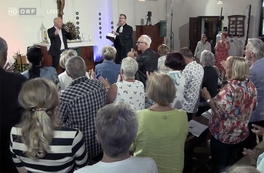 Worshippers clap during the Aug. 23 Schlager service at the Christuskirche in Graz, Austria, broadcast live by ORF III.