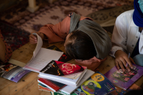 A student thumbs through a notebook during class at a secret school on August 14, 2022 in Kabul, Afghanistan.