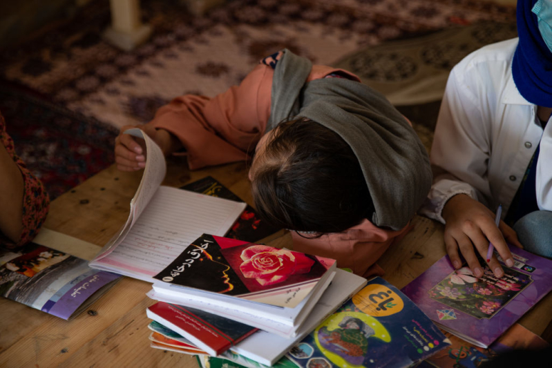 A student thumbs through a notebook during class at a secret school on August 14, 2022 in Kabul, Afghanistan.