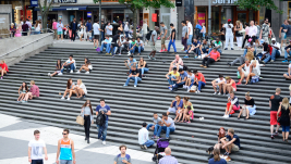 People sit on the steps at Sergels torg in Stockholm, Sweden.