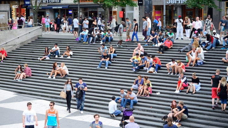 People sit on the steps at Sergels torg in Stockholm, Sweden.